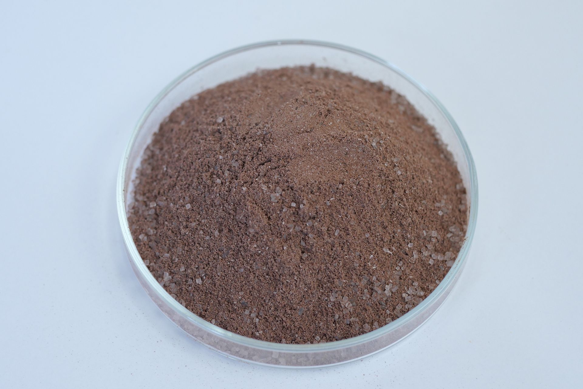 Grainy dark brown colored chocolate pre-mix powder on a dish
